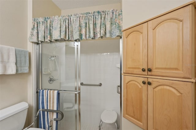 full bath featuring a shower stall and toilet