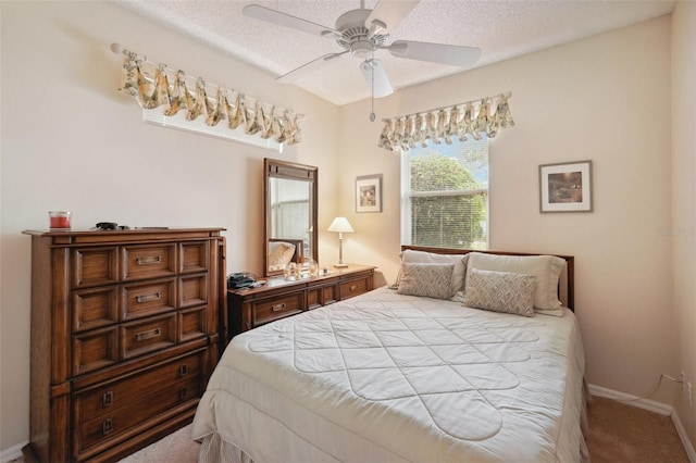 bedroom featuring a ceiling fan, baseboards, carpet floors, and a textured ceiling