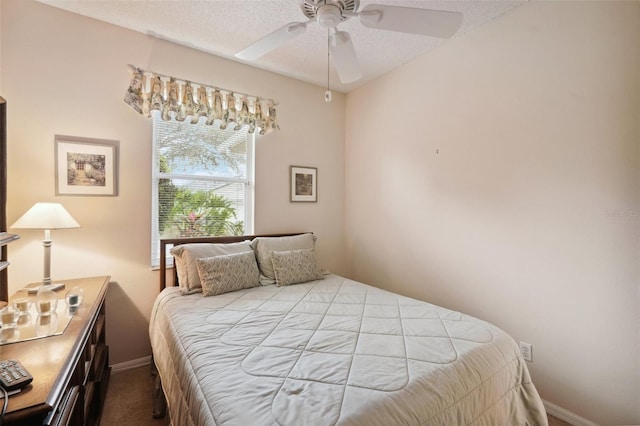 bedroom with baseboards, a textured ceiling, a ceiling fan, and carpet floors