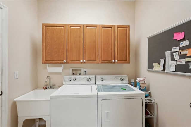 laundry room with washer and dryer, cabinet space, and a sink