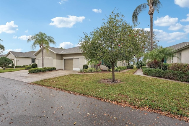 view of front of house with stucco siding, a front yard, an attached garage, and driveway