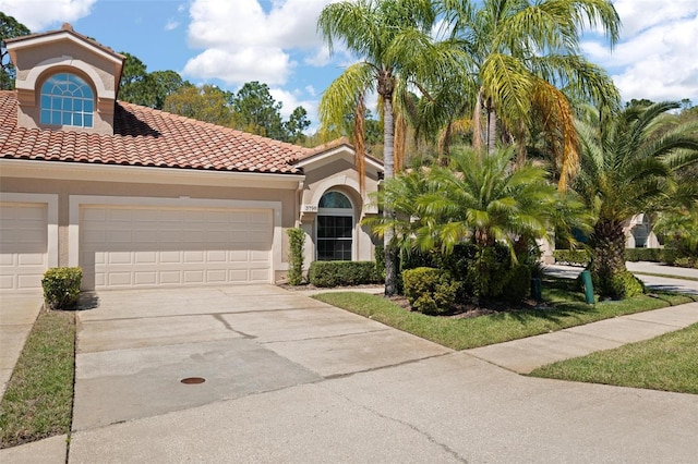 mediterranean / spanish-style house featuring a garage, a tile roof, concrete driveway, and stucco siding