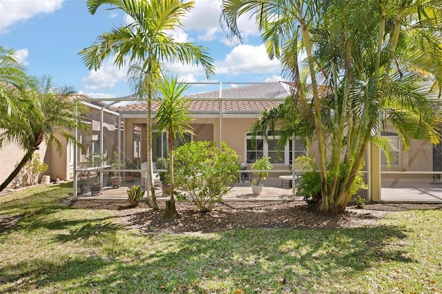 3798 Darston St, Palm Harbor, FL 34685 - rear view of house with a tile roof, a yard, stucco siding, a patio area, and a lanai