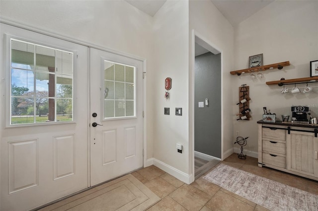 entryway with light tile patterned floors and baseboards