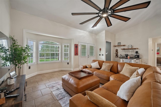 living area with lofted ceiling, tile patterned flooring, a ceiling fan, and baseboards