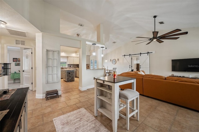 kitchen featuring a barn door, dark countertops, and visible vents