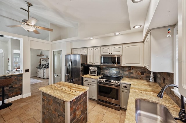 kitchen featuring a center island, a sink, vaulted ceiling, stainless steel appliances, and backsplash