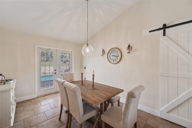 dining area with a barn door, baseboards, lofted ceiling, french doors, and light tile patterned flooring