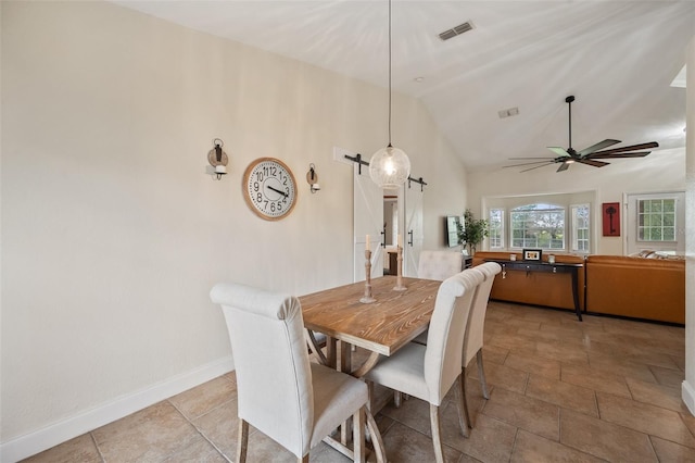 dining area with lofted ceiling, visible vents, a barn door, a ceiling fan, and baseboards