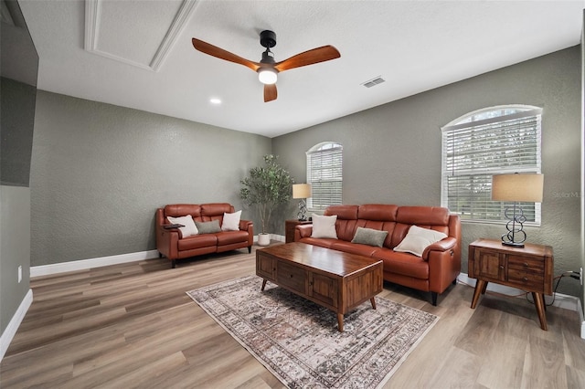 living area featuring light wood-style floors, plenty of natural light, and baseboards