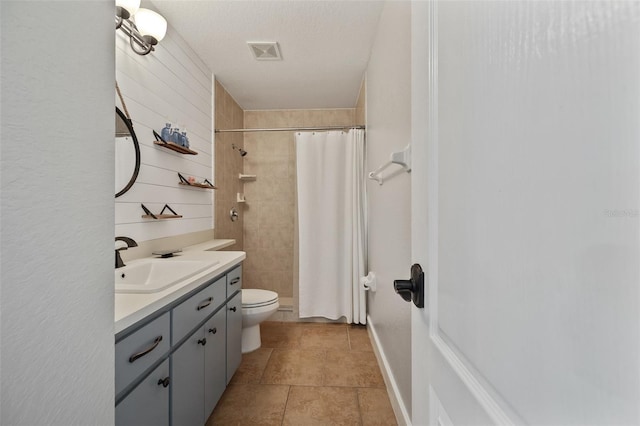 bathroom with visible vents, vanity, toilet, and tiled shower