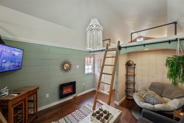 living area with baseboards, wood finished floors, and a glass covered fireplace