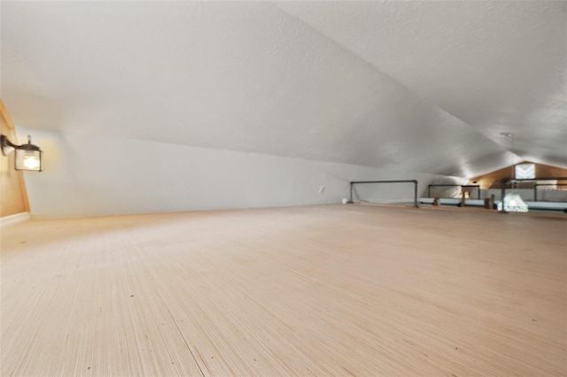 bonus room featuring vaulted ceiling and a textured ceiling