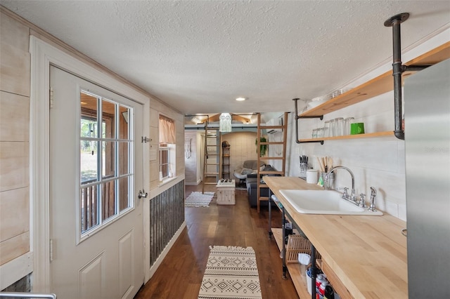 kitchen with dark wood-style flooring, a sink, a textured ceiling, and open shelves