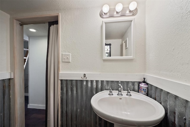 bathroom featuring a textured wall and a sink