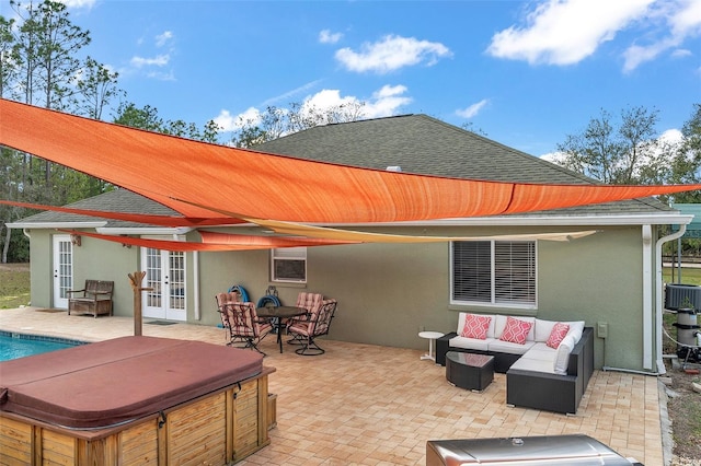 rear view of house with french doors, stucco siding, a hot tub, an outdoor hangout area, and a patio area