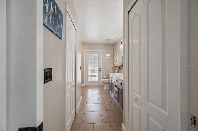 interior space featuring tile patterned flooring, light countertops, and a textured ceiling