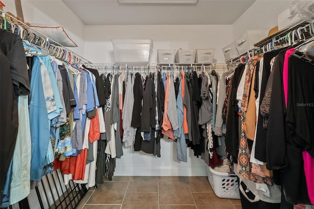 spacious closet featuring tile patterned flooring and attic access