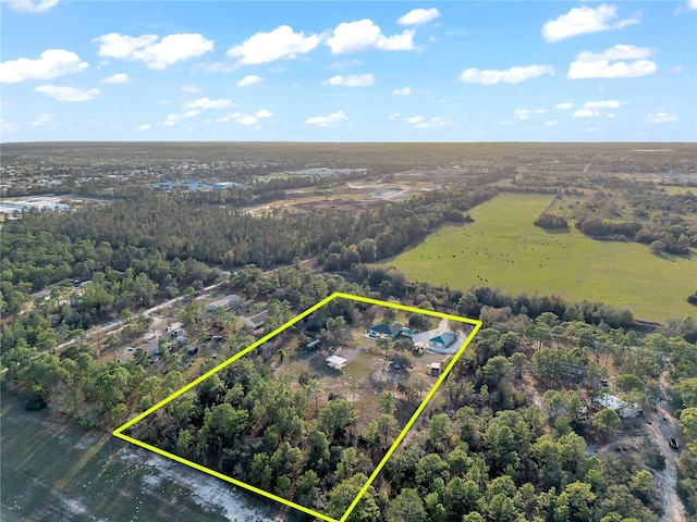 birds eye view of property with a wooded view