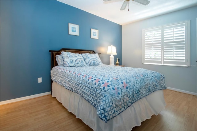 bedroom featuring a ceiling fan, baseboards, and wood finished floors