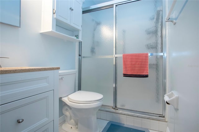 bathroom featuring toilet, a shower stall, and vanity