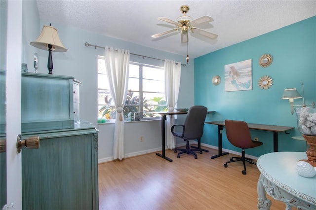 office area with ceiling fan, a textured ceiling, baseboards, and wood finished floors