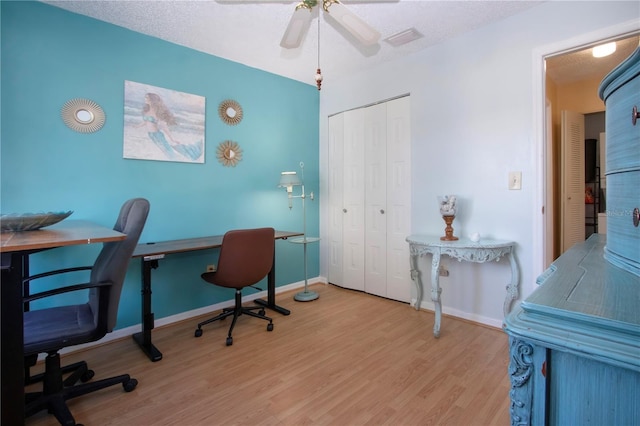 office area featuring visible vents, ceiling fan, baseboards, and wood finished floors