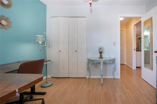 office area with a textured ceiling, wood finished floors, and baseboards