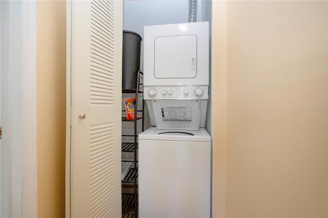 clothes washing area featuring stacked washer and dryer and laundry area