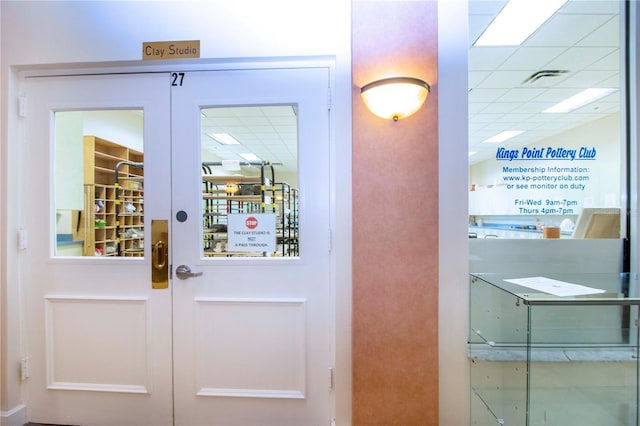 doorway featuring french doors and a drop ceiling