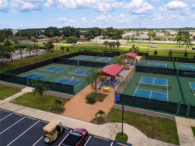 view of tennis court featuring fence and a yard