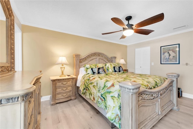 bedroom featuring ornamental molding, light wood-type flooring, and visible vents