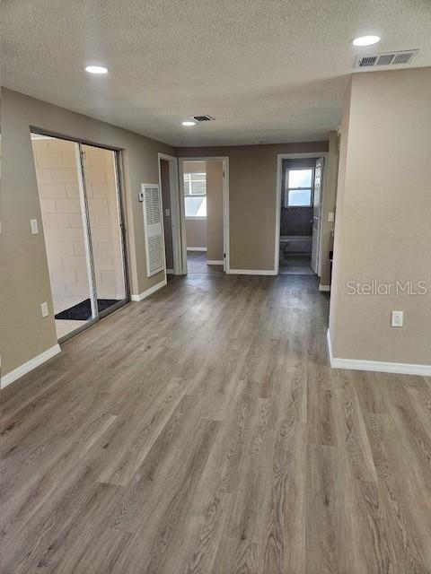 spare room featuring a healthy amount of sunlight, baseboards, and wood finished floors