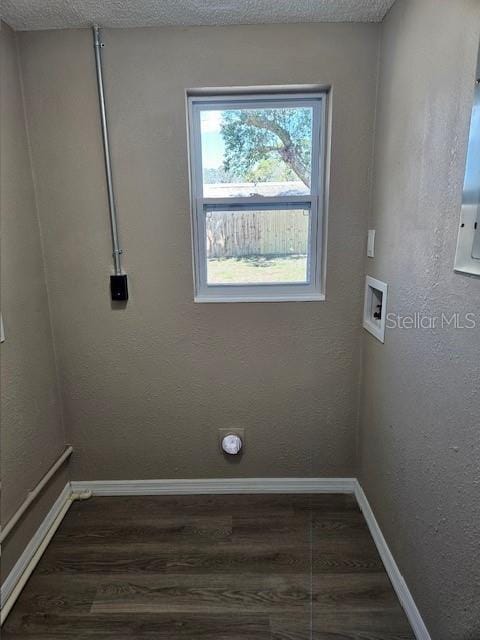 laundry area with laundry area, dark wood-type flooring, washer hookup, and baseboards