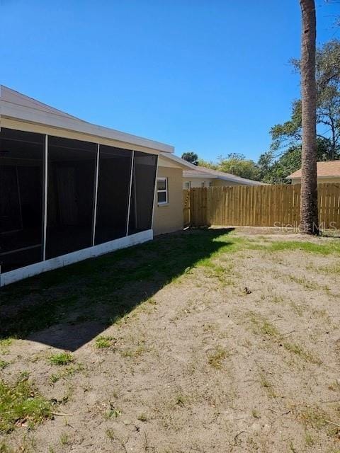 view of yard with fence and a sunroom