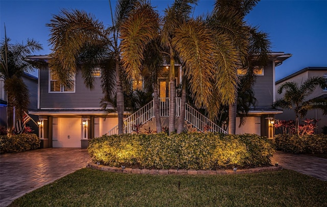 view of front of home featuring a garage, stairway, and decorative driveway