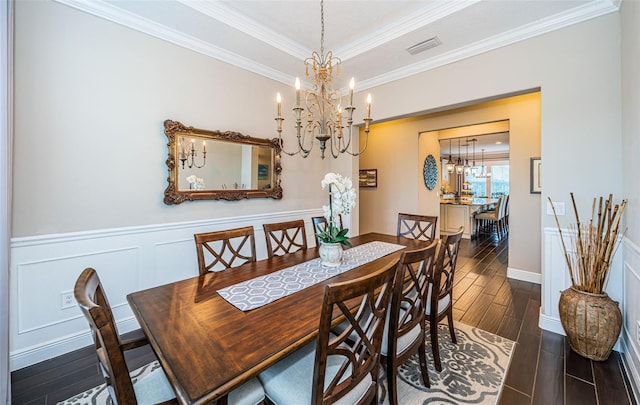 dining space featuring a wainscoted wall, visible vents, wood tiled floor, an inviting chandelier, and crown molding