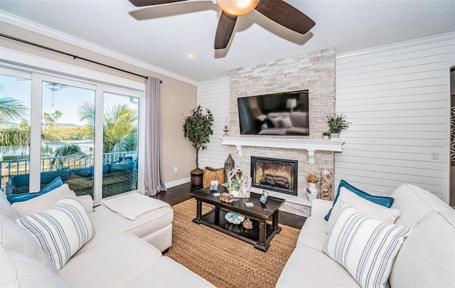 living room featuring ornamental molding, a fireplace, wood finished floors, and baseboards