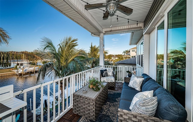 balcony featuring ceiling fan, a water view, and an outdoor living space