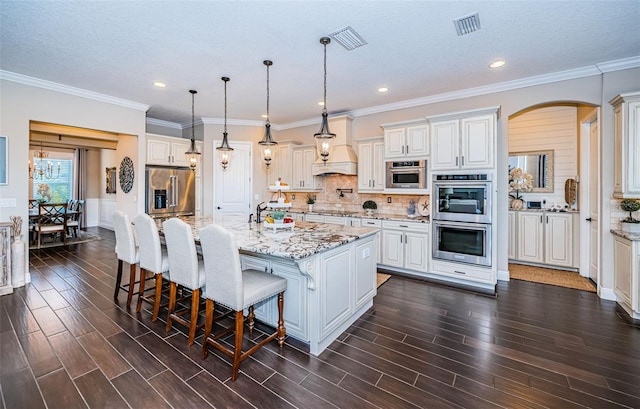 kitchen with stainless steel appliances, backsplash, visible vents, and wood tiled floor