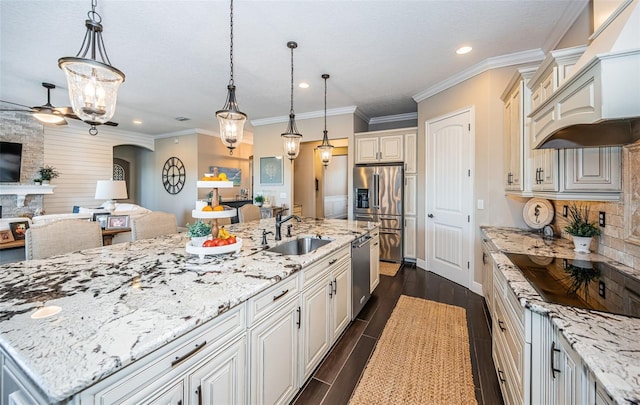 kitchen featuring stainless steel appliances, premium range hood, a fireplace, a sink, and open floor plan