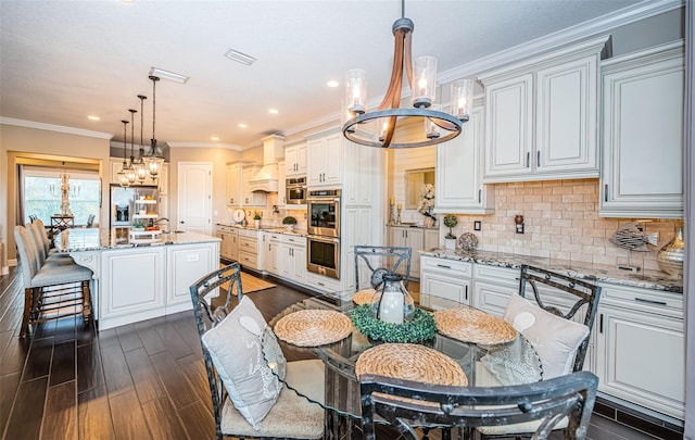 dining area featuring dark wood-style floors, crown molding, recessed lighting, visible vents, and an inviting chandelier