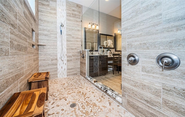 bathroom with tiled shower and vanity