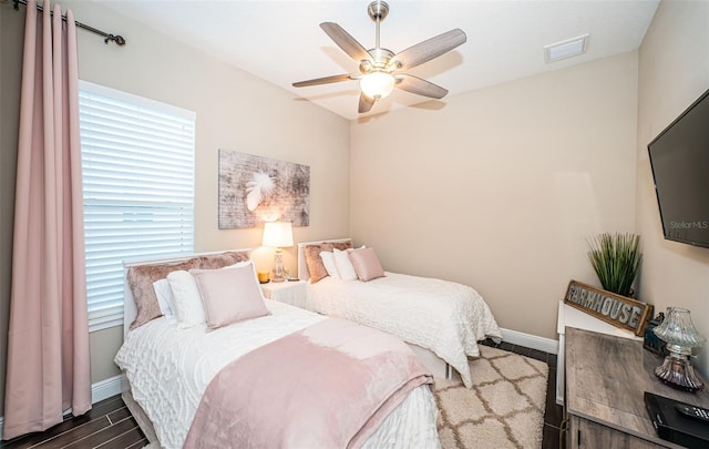 bedroom featuring dark wood-style flooring, multiple windows, visible vents, and baseboards