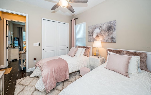 bedroom with a ceiling fan, wood tiled floor, a closet, and baseboards