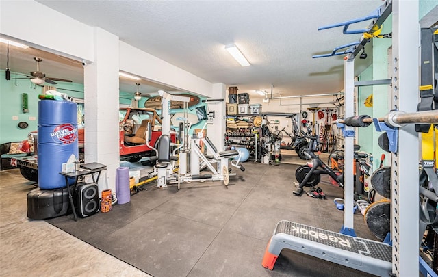 workout area featuring ceiling fan and a textured ceiling