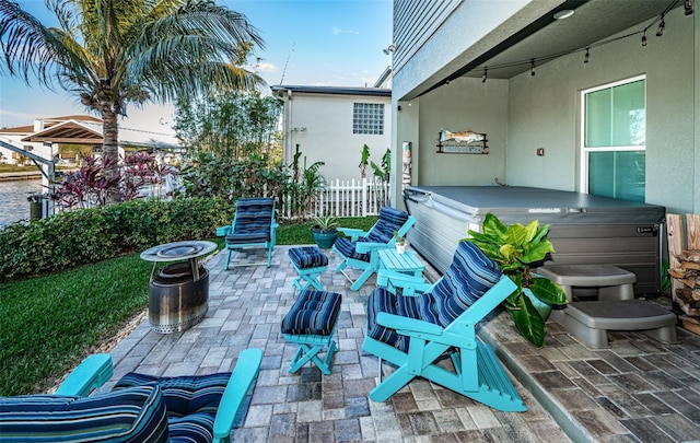 view of patio with fence and a hot tub