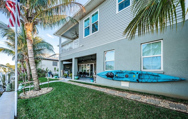 view of yard with a patio area, ceiling fan, and a balcony