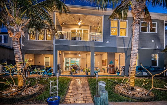 back of property featuring a balcony, stucco siding, ceiling fan, and a patio