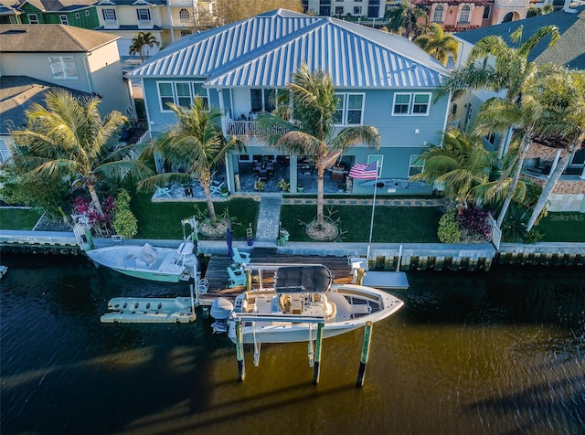 rear view of house with a water view and boat lift